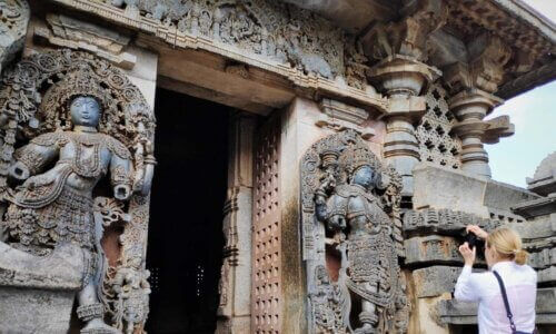 A woman is taking a picture of an ornate doorway. Hoysala Temples Hassan