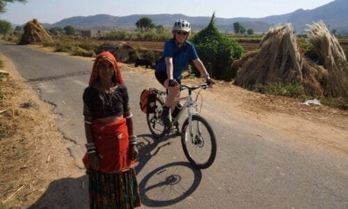 Rajasthani village women and a woman on a bicycle on a rural road. Khejarla, Rajasthan, India
