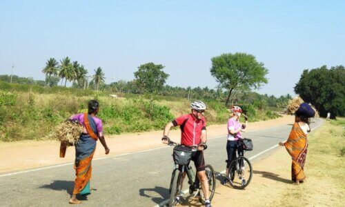 A group of people riding bicycles down a country road.