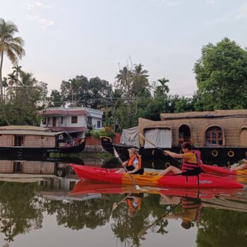 A serene view of Vembanadu Lake in Kerala, with calm waters reflecting the lush greenery of the surrounding landscape, capturing the tranquility and natural beauty of the region.