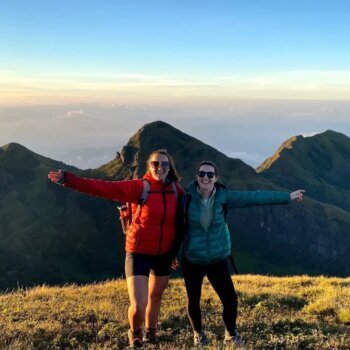 A stunning view from the highest point of Meesapulimala, Kerala, showcasing the rolling hills and mist-covered peaks of the Western Ghats, with trekkers taking in the panoramic scenery.