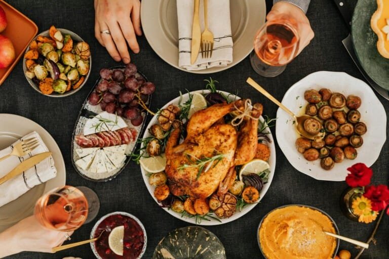 A dining table showcasing a delicious turkey, assorted vegetables, and a bottle of wine